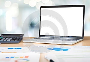 Mockup laptop computer screen with business chart market,caculator on desk at blur hallway modern office meeting room.device