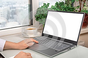 Mockup laptop. woman using laptop with blank white screen and coffee cup on glass table in modern home office