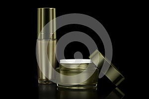 Mockup luxury golden cream jar is uncover and luxury golden container cream pump bottle, isolated black background.