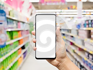 Mockup mobile phone with blank white screen. Hand holding smartphone with blurred supermarket background for your online