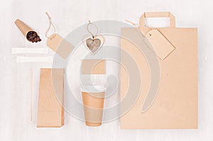 Mockup packing for coffee products and shop - brown paper cup, blank bag, packet, label, card, heart, coffee beans, sugar on wood.