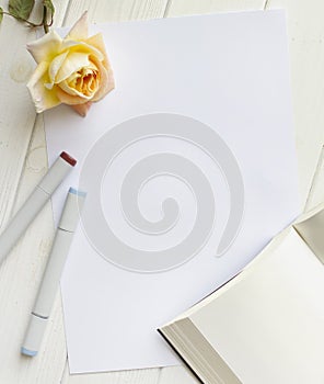 Mockup for A4 paper with single rose, book and drawing material