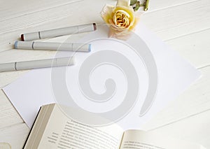 Mockup for A4 paper with single rose, book and drawing material