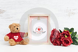 Mockup Picture frame and cute bear with Bouquet of red roses on grunge white wood. Valentines Day Background concept with copy