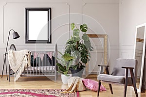Mockup poster in grey baby room interior with green plants and retro armchair,