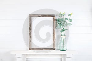 Mockup of a rough wooden frame on a white wall background in the interior