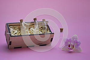Mockup of samples with perfume, aromatic oils in a wooden box on a colored background Mockup of glass bottles of perfume, blank