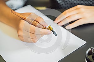 MOCKUP, SCENE CREATOR Calligrapher Young Woman writes phrase on white paper. Inscribing ornamental decorated letters