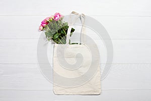 Mockup shopper handbag. Pink roses. Wood background. Top view copy space shopping eco reusable bag. Mothers women day. Template