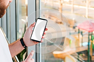 Mockup smartphone in man hand black mobile phone with blank white screen, copy space screen for your text or design or app behind