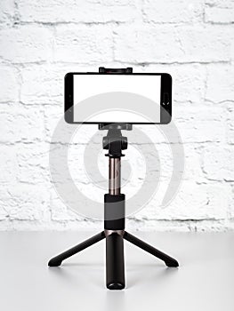 Mockup with smartphone on a tripod with empty screen