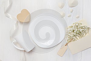 Mockup for St. Valentine`s Day greeting card letter in envelope and mug, plate wiht heart box gif, flatlay on a white