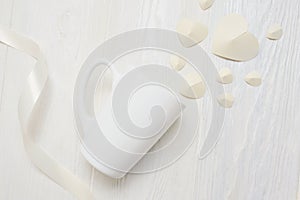 Mockup for St. Valentine`s Day greeting card. mug and white paper heart flatlay on a white wooden background, with place