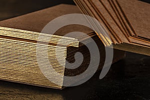 Brown kraft business cards with golden edges mockup on a black background