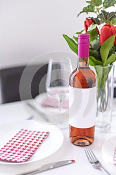Mockup of a standing rose wine bottle on a dining table in natural light
