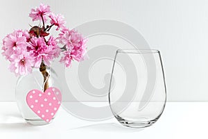 Mockup - stemless wine glass, next to blossom in a vase