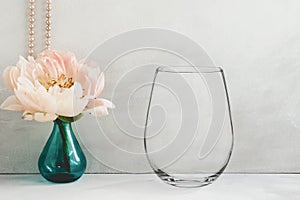 Mockup - stemless wine glass, next to a peony in a vase