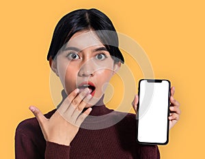 Mockup of a surprised woman presenting a smartphone with summer themed orange background