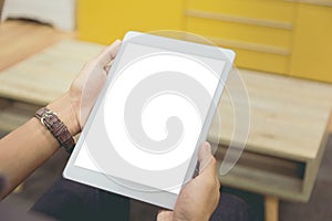 Mockup tablet on businessman hands empty display on home table with blur background