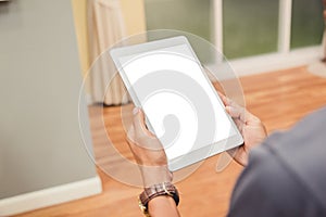 Mockup tablet on businessman hands empty display on home table with blur background