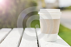 Mockup of take away disposable paper coffee container or cup on street. copy space.
