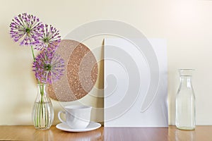 Mockup template with A4 paper sheet, porcelain cup, purple garlic flowers, corc circle