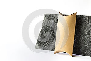 Mockup template with craft paper guft box standing next to raw natural black stone on white background photo