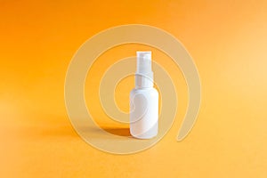 Mockup of unbranded white plastic spray bottle on a textured bright orange background. Natural organic spa cosmetics