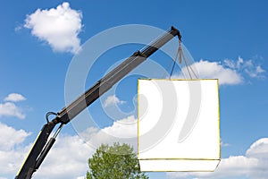 Mockup white box for advertising hanged on crane against blue sky. Product placement, copyspace for text