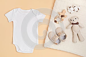 Mockup of white infant bodysuit made of organic cotton with eco friendly baby accessories