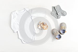 Mockup of white infant bodysuit made of organic cotton with eco friendly baby accessories