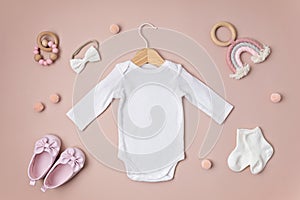 Mockup of white infant bodysuit made of organic cotton with eco friendly baby accessories