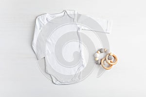 Mockup of white infant bodysuit made of organic cotton with eco friendly baby accessories photo
