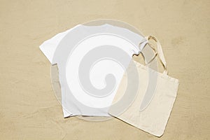 Mockup white not wrinkled summer t-shirt shopper copy space. Sand beach texture background. Blank template woman man shirt Top