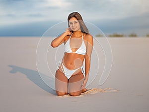 Mockup of a white swimsuit, bikini on a girl sitting on the beach, on the background of nature, the sky