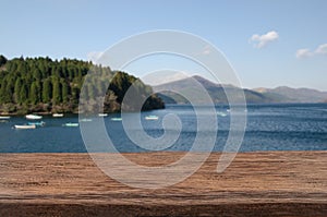 Mockup wood table for product display with blurred sea and mountain landscape