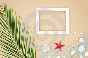 Mockup wooden frame with starfish and seashells. Flat lay with palm leaf and beach sand. Top view Template with copy