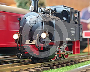 Model 99 steam locomotive on the rail with the passing train behind it