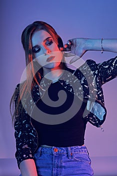 Model with air style. Woman in colorful bright lights posing in studio, portrait of beautiful girl with trendy make-up and