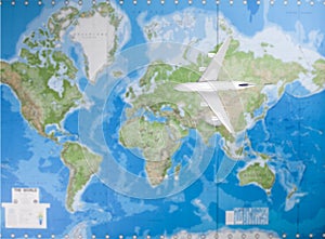Model airplane flying over world map