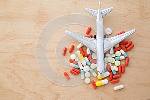 model airplane with multicolored pills from motion sickness close-up on a wooden background. flat lay. concept illness in travel.