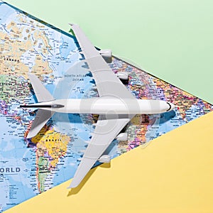 Model airplane on paper background opens a world map