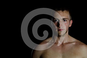 Model with athletic body posing on a black background