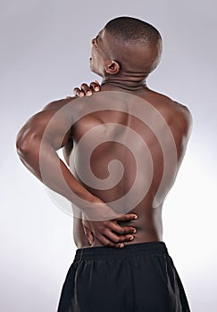 Model, back pain and injury with fitness exercise or health, medical problem and aching body in studio. Emergency, male