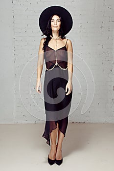 Model in black diaphanous clothes staying studio