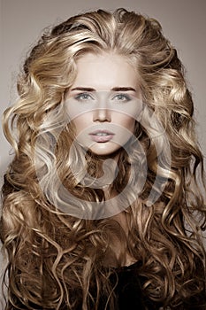 Model with blonde long hair. Waves Curls Hairstyle. Hair Salon.