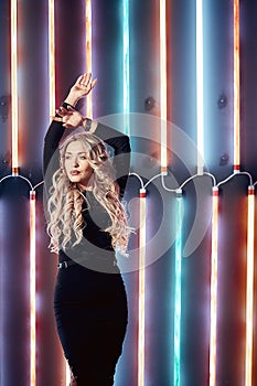 Model blonde woman in colorful bright neon lights posing in the Studio. Beautiful sexy girl, trendy glowing makeup.