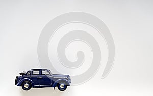 Model of a blue vintage children`s car on white isolate, place for text