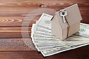 Model cardboard home, key and dollar money. House building, insurance, housewarming, loan, real estate, cost of housing, buying photo