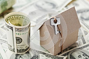 Model cardboard home, key and dollar money. House building, insurance, housewarming, loan, real estate, cost of housing, buying